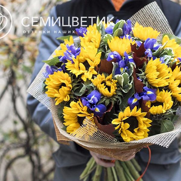 Букет из подсолнухов, ирисов и гиперикума в натуральной упаковке