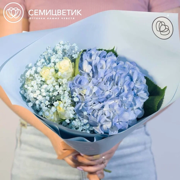 Букет из гортензии, гипсофилы и белой розы в голубой пленке
