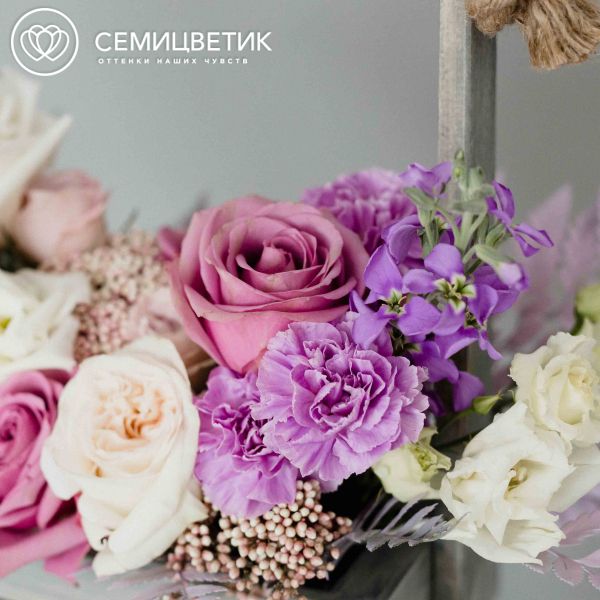 Стильный дизайнерский букет в ящике из роз, гвоздик и лизиантусов в сиреневых тонах
