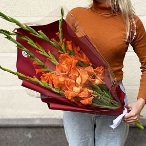 Большой букет  из 5 оранжевых гладиолусов в бордовой пленке
