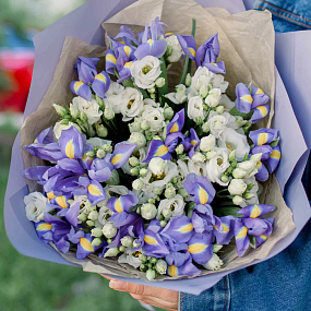 Букет из 15 синих ирисов и 7 белых лизиантусов в сиреневой пленке