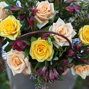 Композиция в жёлтых тонах из роз, альстромерии в сумочке