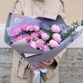 Букет из 9 розовых гвоздик и 7 розовых пионов Standart Plus с зеленью в сиреневой пленке