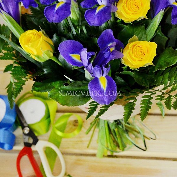 Букет из роз и ирисов с зеленью в упаковке