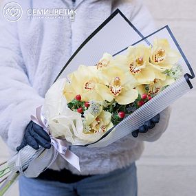 Букет из орхидеи желтой, астранции и красного гиперикума в бордовой пленке