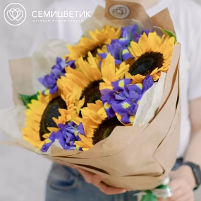 Букет из 5 подсолнухов и 10 синих ирисов в кремовой пленке