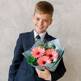 Букет из коралловых гербер и белых альстромерий с зеленью в голубой пленке