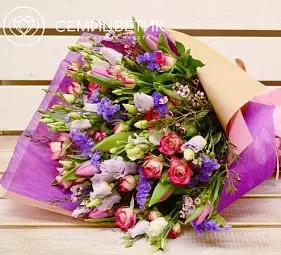 Букет из тюльпанов, лизиантуса и розы кустовой с зеленью в кремовой пленке